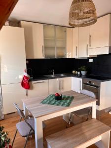 een keuken met een tafel en stoelen en een keuken met witte kasten bij Duplex au cœur de Turckheim, 10 min de Colmar et place de parking in Turckheim