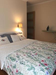 una camera da letto con un grande letto con un copriletto floreale di Appartement Taverny a Taverny