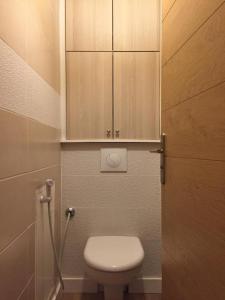uma casa de banho com WC e um armário de madeira em Appartement Taverny em Taverny