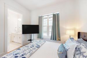 una camera da letto con un letto, una TV e una finestra di Coastal Vista Retreat a Port Aransas