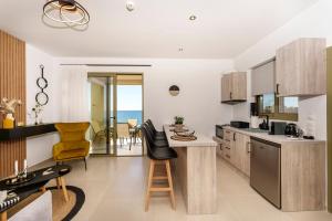 a kitchen with a table and chairs in a room at Anassa Villas in Keratokampos
