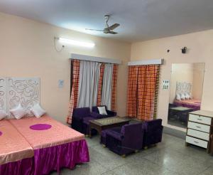 a bedroom with two beds and a couch and a table at Huge Private two double beds family room in Kānpur