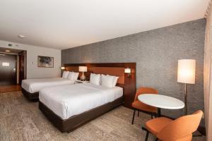 a hotel room with two beds and a table and chairs at Quality Inn & Suites in Val-dʼOr +58 photos
