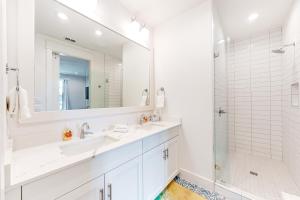 un bagno bianco con 2 lavandini e una doccia di Coastal Vista Retreat a Port Aransas Altre 18 foto