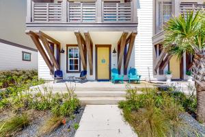 una casa con una porta gialla e sedie blu di Coastal Vista Retreat a Port Aransas