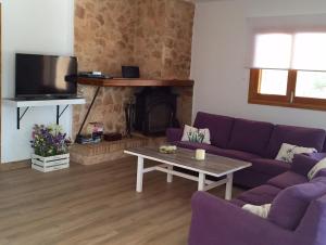 uma sala de estar com um sofá roxo e uma mesa em SON BUSQUERET em Ses Covetes