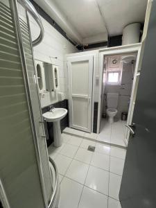 a small bathroom with a toilet and a sink at NEWBORN comfort HOSTEL in Pristina