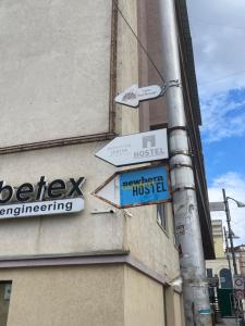 a pole with street signs on the side of a building at NEWBORN comfort HOSTEL in Pristina