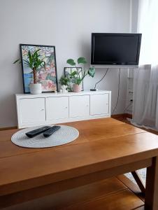 a living room with a tv and a table at Apartament Widok in Świebodzin