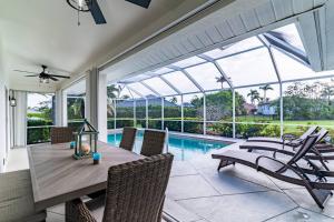 Your Ultimate Coastal Retreat في جزيرة ماركو: غرفة طعام مع طاولة وكراسي ومسبح