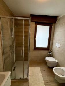a bathroom with a shower and a toilet and a sink at Tati&Ele apartments in Sedico