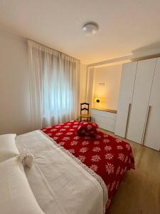 a bedroom with a large bed with a red blanket at Tati&Ele apartments in Sedico