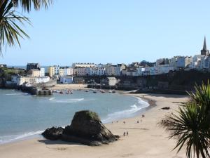 a beach with people and a rock in the water at 2 Bed in Neyland 43430 in Llanstadwell