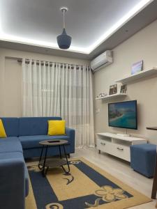 un soggiorno con divano blu e TV di Sirel Home a Durrës