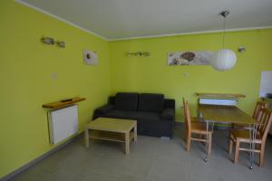 a living room with a couch and a table at Domyletnie Sarbinowo Mały Dom 46 m2 z ogrodzoną działką in Sarbinowo