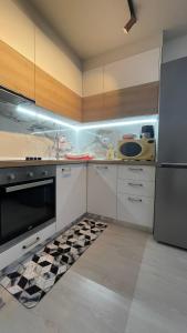 uma cozinha com armários brancos e um aparelho preto em Sirel Home em Durrës