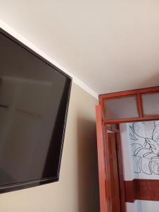 uma televisão de ecrã plano numa parede ao lado de uma janela em Goya'sHostel em Camaná