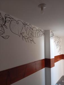 a wall with a drawing of leaves on it at Goya'sHostel in Camaná