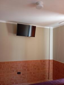 a television hanging from the ceiling of a room at Goya'sHostel in Camaná