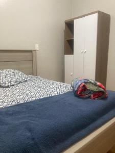 a bedroom with a bed with a blue blanket on it at Apartamento em Passo Fundo in Passo Fundo