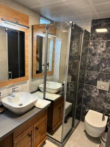 a bathroom with two sinks and a shower and a toilet at Lotus City Sığacık in Seferihisar