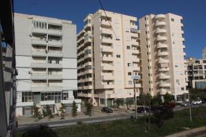 two tall buildings with trees in front of a street at Sirel Home in Durrës