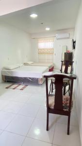a room with a bed and a table and a chair at Departamento Piso 1-B in Asuncion +1 photo