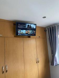 TV en la parte superior de los armarios de una habitación en Three Bedroom House, Driveway, Bracknell Centre en Bracknell