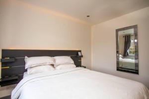 a bedroom with a large white bed with a mirror at Three Bedroom House, Driveway, Bracknell Centre in Bracknell