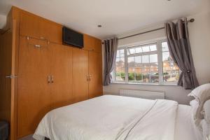 a bedroom with a white bed and a window at Three Bedroom House, Driveway, Bracknell Centre in Bracknell