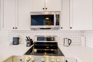 una cocina con estufa y microondas en Ice and Cozy #116C, en Big White