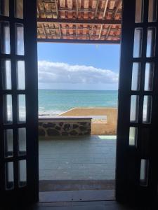 a view of the ocean from a room with a window at Pousada Tubarão in Camaçari