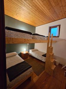 a room with two bunk beds and a staircase at Rifugio Guglielmo e Giovanni Pelizzo in Montemaggiore