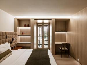 a bedroom with a bed and a desk and a chair at Pulso Hotel Faria Lima in São Paulo