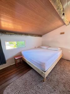 a large bed in a room with a window at Hostel Caraivando in Caraíva