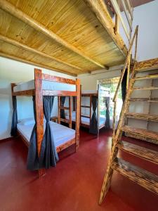 a room with two bunk beds and a ladder at Hostel Caraivando in Caraíva