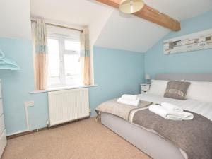 a bedroom with blue walls and a bed with towels on it at 3 Bed in Aberaeron 49854 in Henfynyw Upper