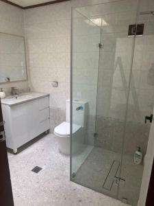 a bathroom with a toilet and a glass shower at Relax in Chipping Norton Entire Home 3 bedrooms in Chipping Norton