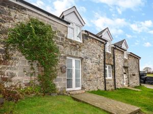 an old stone house with white windows and a green yard at 3 Bed in Aberaeron 49854 in Henfynyw Upper