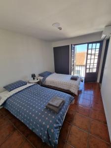 a bedroom with two beds and a large window at Alvorada Lunar in Almeirim