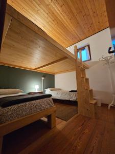 a bedroom with two bunk beds and a wooden ceiling at Rifugio Guglielmo e Giovanni Pelizzo in Montemaggiore