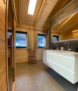ein Badezimmer mit einem großen Waschbecken und zwei Fenstern in der Unterkunft Naturparadies Pressegger See - Nassfeld - Weissensee in Hermagor