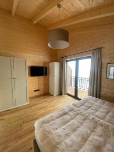 a bedroom with a bed and a large window at Naturparadies Pressegger See - Nassfeld - Weissensee in Hermagor
