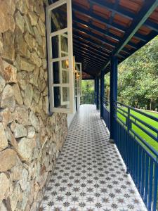 une terrasse couverte avec un mur en pierre et une fenêtre dans l'établissement Fazenda São Miguel, à Monte Alegre do Sul