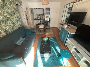 een woonkamer met een bank en een tafel bij Splendide appartement 40m2 familial cabourg in Cabourg
