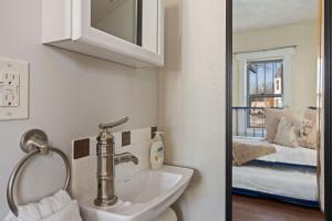 a bathroom with a sink and a bedroom at Newly Renovated in the Heart of Historic Loveland in Loveland