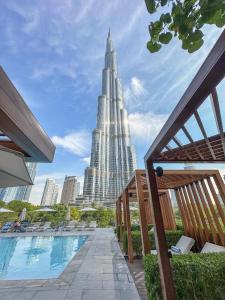 a large building with a pool in front of a city at Luxury 1BR The Address Opera, Downtown Dubai in Dubai