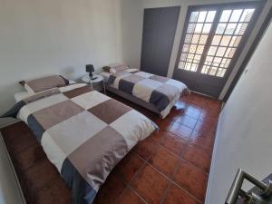 a bedroom with two beds and a floor at Alvorada Lunar in Almeirim