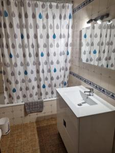 a bathroom with a sink and a shower curtain at Alvorada Lunar in Almeirim