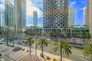 a city street with palm trees and tall buildings at Address Opera Residences - Elegant Dubai in Dubai